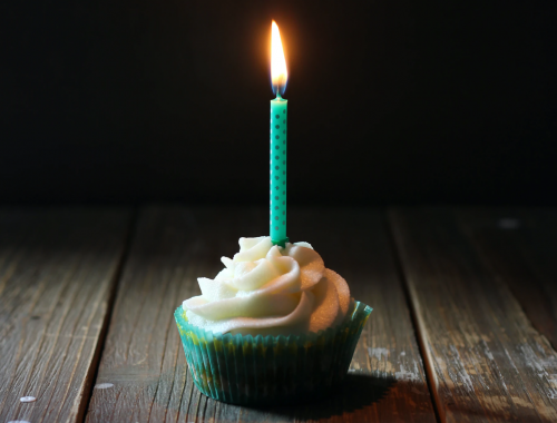 Cumpleaños define la profesión. Cupcake con vela de cumpleaños encendida.
